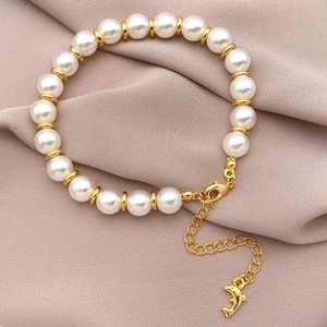Pulsera de perlas blancas con espaciadores de oro de 18k y colgante de delfín