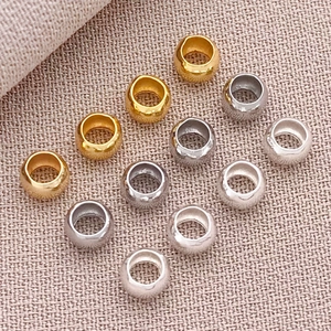 Detailed macro view of 18K gold and silver plated copper spacer beads on linen fabric