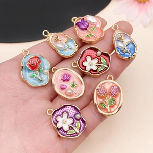 Detailansicht von acht verschiedenen Emaille-Blumenanhängern mit Perlen für DIY-Schmucksets
