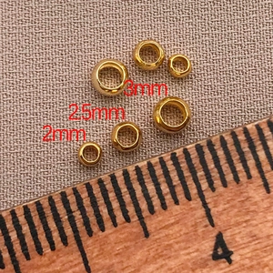 Size comparison of 2mm, 2.5mm, and 3mm 18K gold-plated brass spacer beads on a ruler