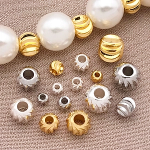Perle distanziatrici placcate oro 18K e perle bianche per gioielli fai-da-te in primo piano