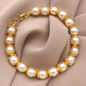 Detailed macro of 18K gold-plated bead chain connectors with white pearls and lobster clasp