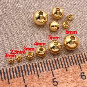 Dettaglio di perle tonde placcate oro 18k con righello in legno per creazioni di gioielli DIY
