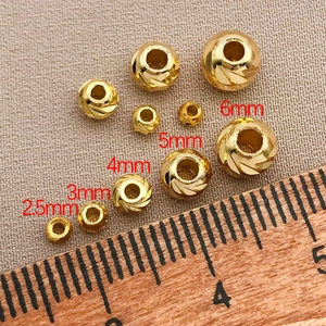 Detailed view of 18K gold-plated spacer beads with spiral texture in sizes 2.5mm to 6mm