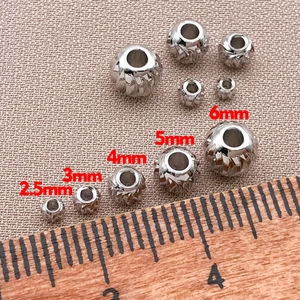 Dettaglio delle perline distanziatrici placcate oro 18K di varie dimensioni su un righello
