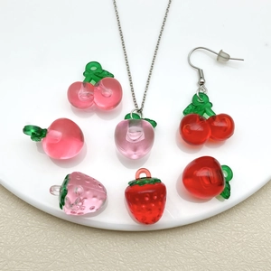 Detailed view of clear resin fruit pendants featuring cherry, strawberry and peach designs