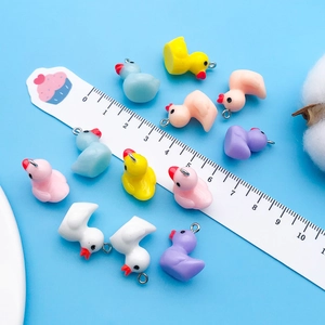 Close-up of colorful resin duck charms with metal loops for DIY jewelry making