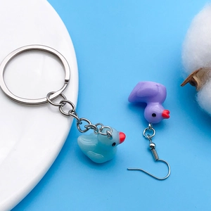 Close-up of cute resin duck charms for earrings and keychains on a blue background