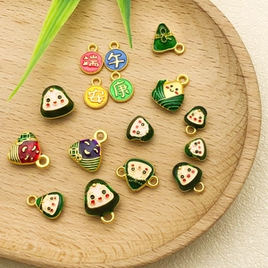 Close-up of enamel Zongzi pendants with festive Dragon Boat Festival patterns on wood