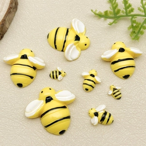 Vue détaillée de cabochons d'abeilles en résine de tailles variées aux rayures jaunes et noires