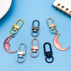 Detailed view of metal swivel lobster clasps with pink and purple enamel moon charms