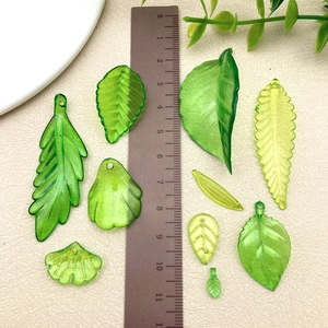 Detailansicht verschiedener grüner Acryl-Blattanhänger mit Löchern für DIY-Schmuckbau