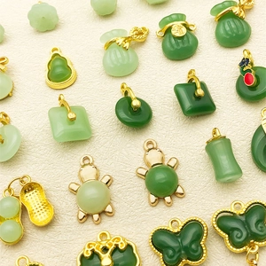 Detailed close-up of green jade-like Chinese lucky charms with gold metal hangers