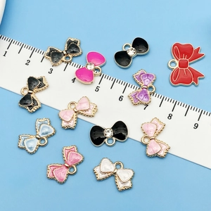 Detalle de colgantes de lazo de aleación de colores con diamantes y regla de medida