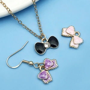 Detalle de dijes de lazo esmaltados de colores con pedrería y cadenas de oro para joyas