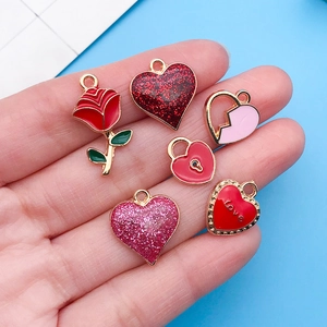 Gros plan de breloques en forme de cœur rouge et rose pour bijoux DIY sur fond bleu