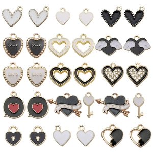Assortimento di ciondoli a cuore in smalto bianco e nero con accenti dorati per gioielli