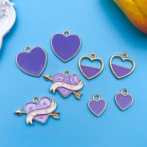 Détail de breloques en forme de cœur émaillé violet avec dorure et gravure LOVE