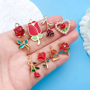 Macro detail of red rose enamel charms with pearls for DIY jewelry making