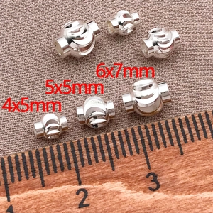 Three sizes of silver lantern beads with spiral grooves measured against a ruler scale