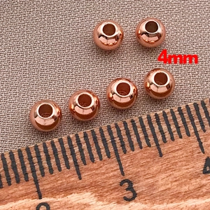 Λεπτομέρεια macro από χάλκινες χάντρες 4mm σε ροζ χρυσό για χειροποίητα κοσμήματα DIY