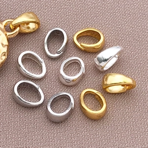 Dettaglio macro di ganci per ciondoli in oro e argento e connettori per gioielli