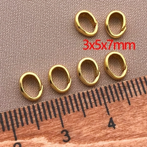 Dettaglio macro di ganci per ciondoli placcati oro 18K 3x5x7mm per gioielli fai-da-te