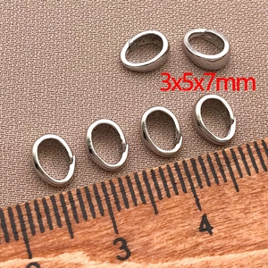 Vista dettagliata dei ganci a clip argento 3x5x7mm con righello per riferimento