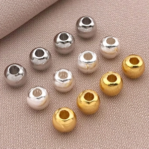 Macro detail of 18k gold-plated textured beads for DIY jewelry making in three colors