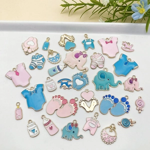 Detalle de dijes esmaltados en rosa y azul para creación de joyería DIY de bebé