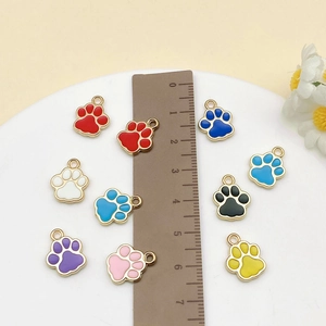 Macro detail of colorful enamel paw prints pendants for DIY jewelry with ruler scale