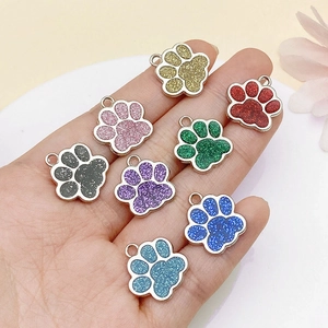 Detail of colorful glitter dog paw pendants with alloy frames and hanging rings for DIY