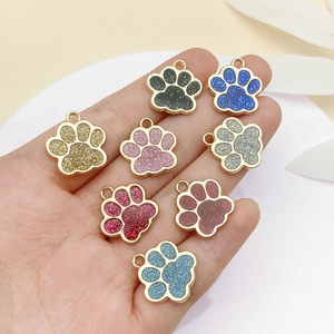Detail of colorful glitter paw print alloy pendants for DIY pet tags and jewelry making
