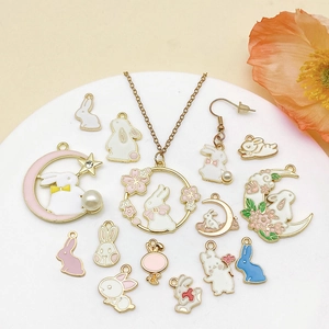 Pastel enamel Easter bunny jewelry set with pearls and moon pendants on a white plate