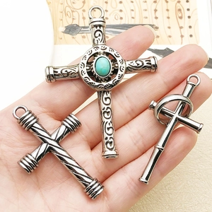Detailansicht der Vintage-Silber-Kreuzanhänger mit Türkis auf einem Stoffhintergrund