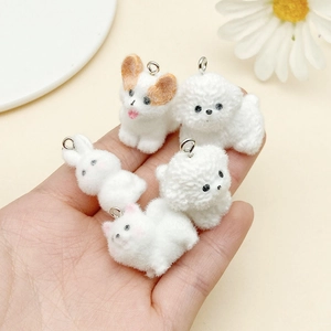 Detailed close-up of 5 cute flocked resin animal charms held in hand for DIY jewelry making
