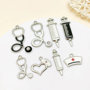 Detailed view of enamel medical charms including stethoscope, syringe and nurse hat for DIY jewelry