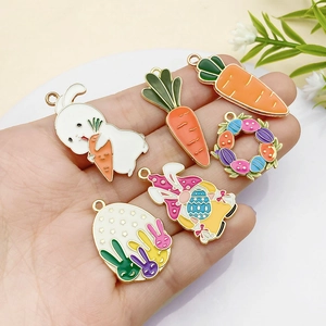 Detail of Easter enamel charms held in hand showing rabbit and carrot patterns