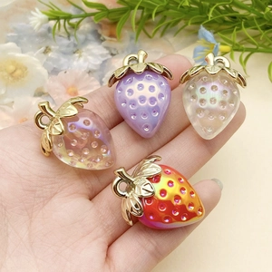 Macro shot of colorful acrylic strawberry pendants with metallic loops for DIY keychains
