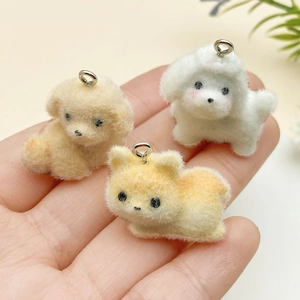 Macro view of three colorful flocked puppy pendants with fuzzy texture and metal loops