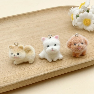 Close-up of three mini flocked dog pendants on a wooden tray with a white daisy decor