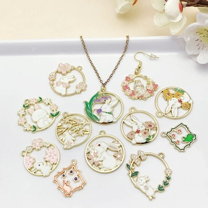 Detailed view of 12 enamel bunny charms with floral motifs for DIY jewelry making