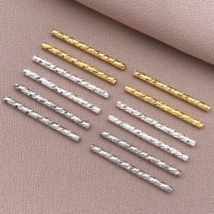 Makroaufnahme von facettierten 18K Gold- und Silber-Zylinderperlen für DIY-Schmuck