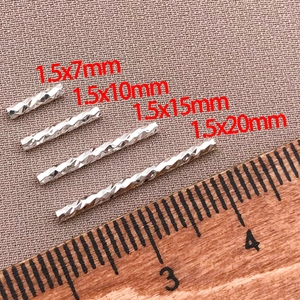 Makroansicht von vier 18K vergoldeten Röhrenperlen in verschiedenen Längen für DIY-Schmuck
