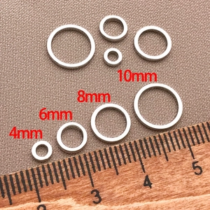 Flat closed jump rings in 4mm to 10mm sizes for DIY jewelry making on wood ruler