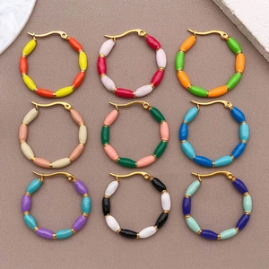 Nine colorful stainless steel enamel bamboo U-shaped hoop earrings on a beige textile base
