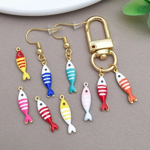 Detail of colorful enamel fish charms with vibrant stripes for DIY jewelry making and crafts