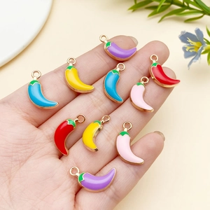 Close-up of colorful enamel chili pepper pendants with gold metal rings for DIY jewelry