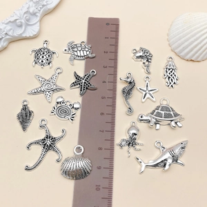Detailed set of antique silver sea creature pendants with measuring ruler for size scaling