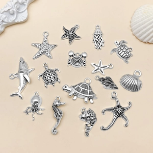 Macro detail of antique silver ocean charms like sharks, starfish and turtles for DIY jewelry